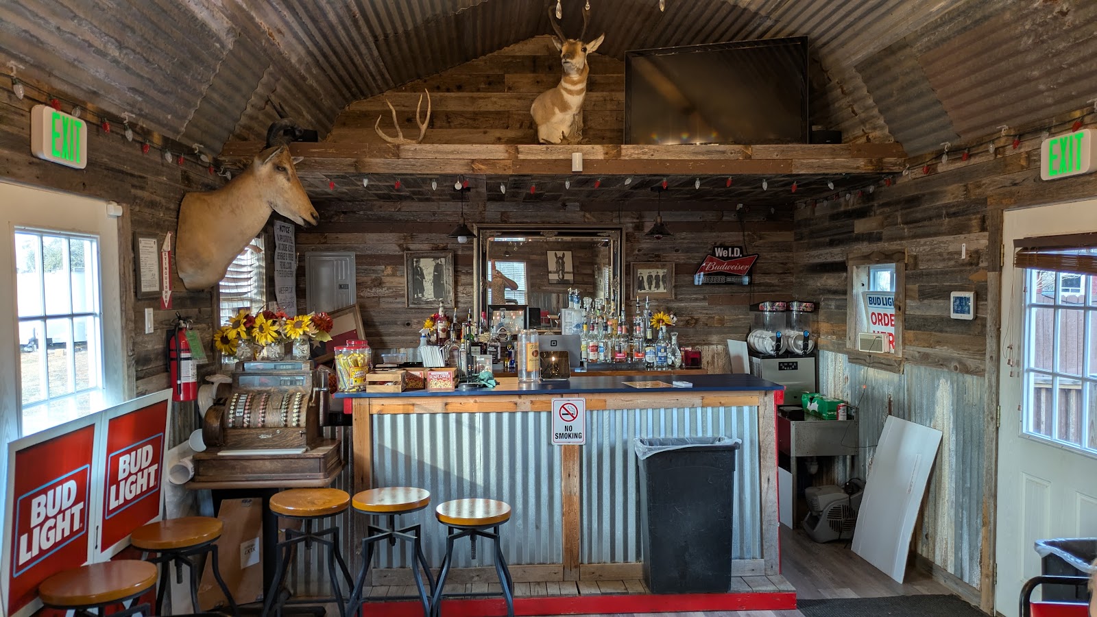 Rustic bar area inside Texas Country BBQ with mounted deer heads and string lights