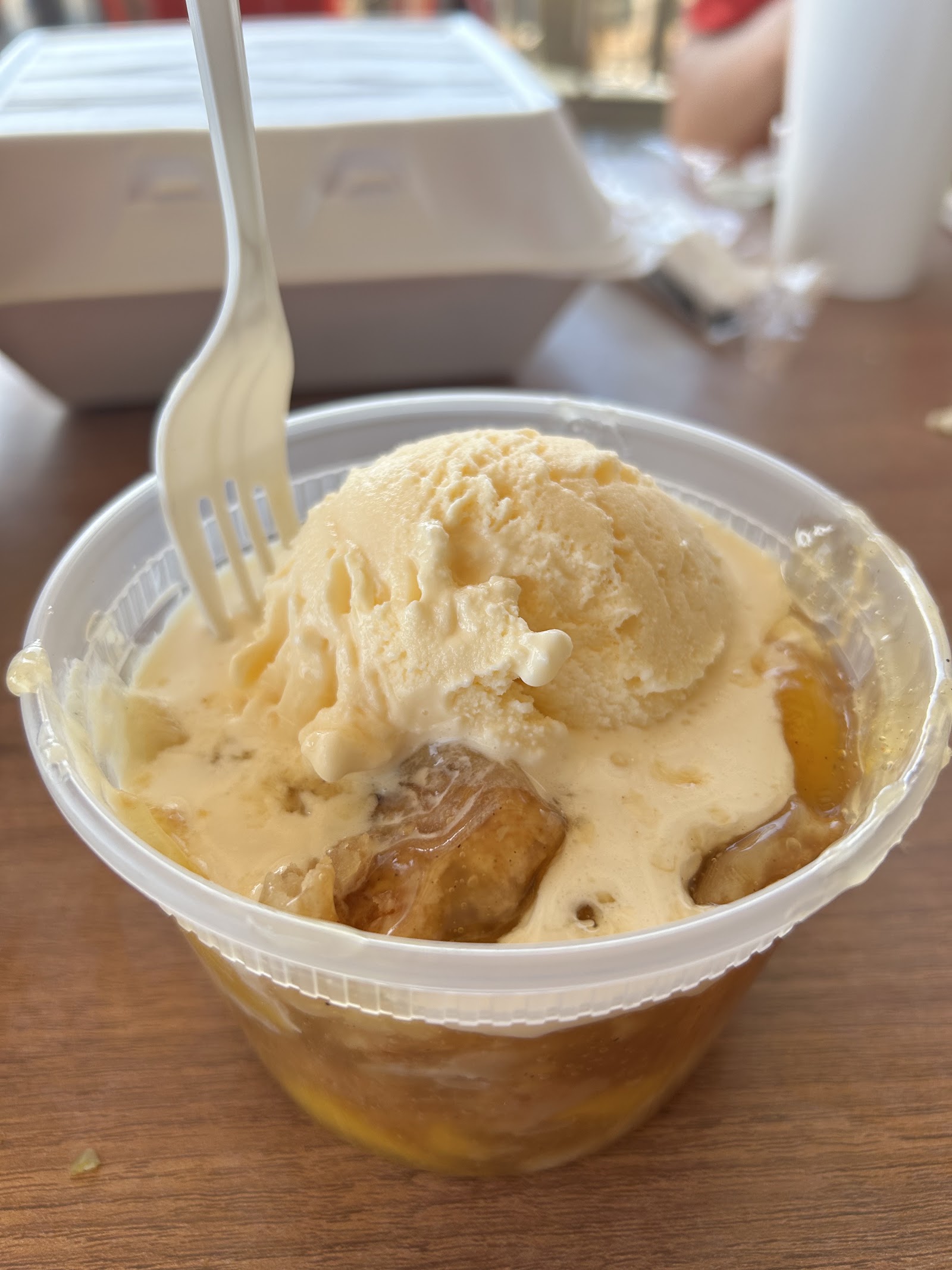 Peach cobbler topped with a scoop of vanilla ice cream
